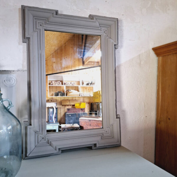 Oude spiegel met sierlijke houten lijst, afgewerkt met krijtverf in grijze tint